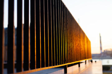 Fototapeta premium Black fence in the rays of the setting sun