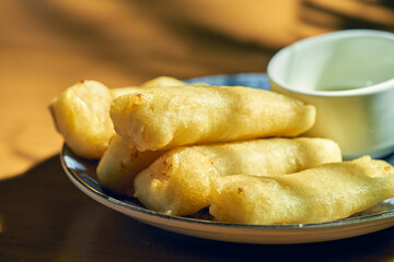 Leche frita or fried milk in a white plate with sweet sauce. Spanish cuisine