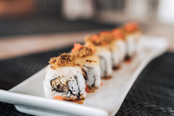 Delicious sushi rolls on plate in restaurant