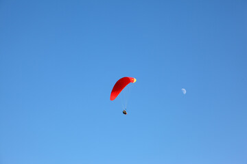 The operated  parachute flies in the blue sky