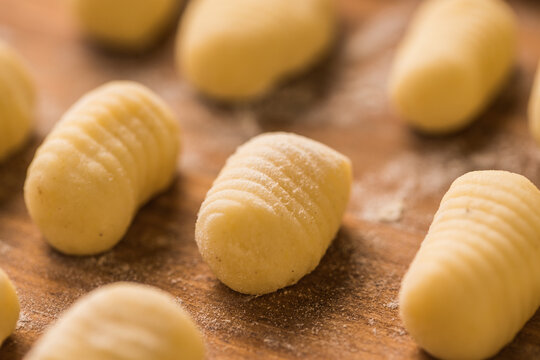 Raw gnocchi on wooden table