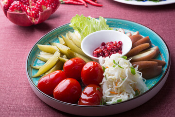 Different pickled vegetables sliced for snack on a plate