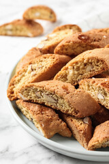 Traditional Italian almond biscuits (Cantucci) on white marble table, closeup