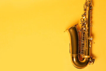 Beautiful saxophone on yellow background, top view. Space for text