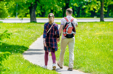 A guy and a girl walk along the path in the city Park
