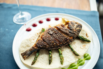 Dish of gourmet grilled dorada fish on the restaurant table
