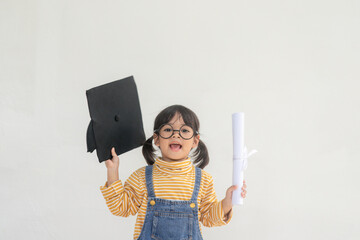Asian Little girl wearing a graduation cap and holding diploma on white background