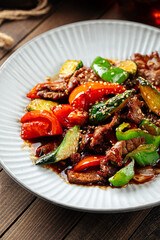 Chinese warm beef salad with vegetables and sesame seeds