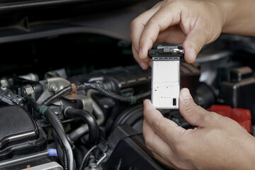 Technician remove a bolt of airflow sensor in the engine room car for check and cleaning in service...