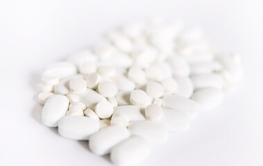 Fototapeta na wymiar White pills on a White background. Healthcare and medicine. 