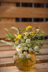 Composition of white and yellow flowers in a glass vase.