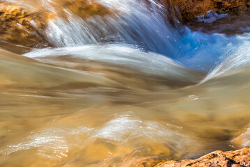 Blurred view of flowing waters against red rocks