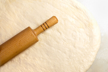 rolling pin on the background of rolled dough