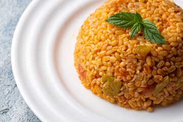 Traditional turkish bulgur pilaf with tomato sause in plate (Turkish name; meyhane pilavi)