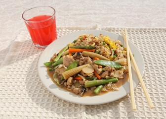 table setting with Chinese chicken stir-fry, chopsticks and red drink