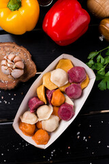 boiled dumplings assorted, different colors ravioli on wooden table