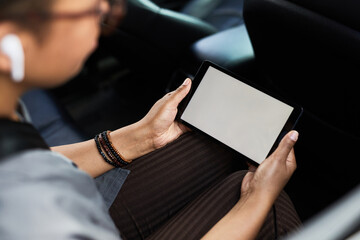 Close-up of woman sitting in the car and watching video online using mobile phone