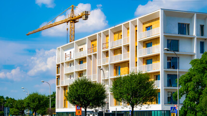 modern apartment block, construction site, crane.