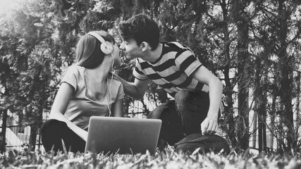 Black and white view of multi ethnic couple enjoying free time at the park. Education concept