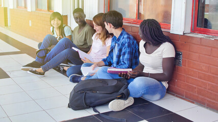 Diversity Students Friends Happiness Concept. Five schoolmates seated in the school hallway