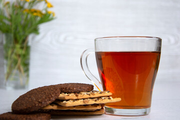 Tea with cookies. A glass cup of hot tea and a bunch of chocolate chip cookies.