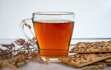 Tea with cookies. Glass cup with hot tea, biscuits and dry sedge.