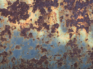 Heavily ruined metal surface textured with big rust spots background  