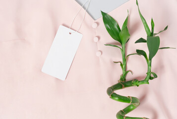 White clothing tag, label blank mockup template, to place your design. On a premium cotton pink blouse fabric textile background. Bamboo