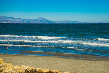 Two fishing poles at the shore of sea.