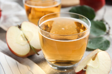 Delicious cider and ripe apple on table, closeup