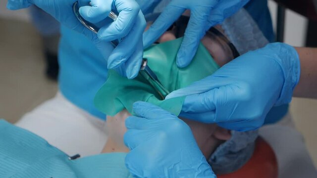 Dental treatment cofferdam in stomatology. Dentist using dental dam for tooth isolation