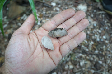 Two small white quartz stones were on the palm of hand.
