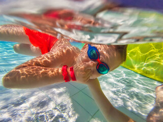 Little boy is snorkeling in the pool on the summer holidays.