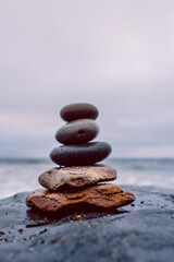 Pyramid of stones by the ocean at blue hour