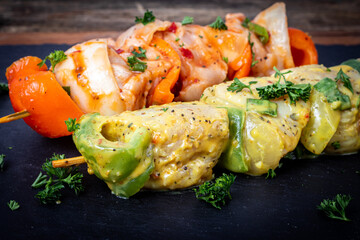 Raw chicken skewers in marinade with spices and herbs