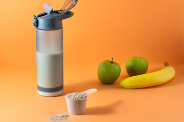 Sports nutrition . Protein scoop, plastic bottle with ready-made drink, two green apples, banana....