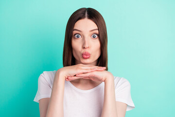 Portrait of attractive amazed funny girlish girl sending air kiss isolated over vibrant teal...