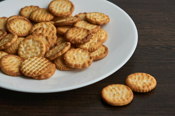 Baked cookies on white plate on wooden background.