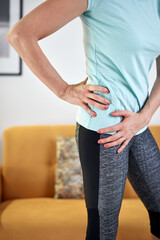 Woman with hip - stomach pain at home.