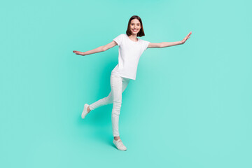 Fototapeta na wymiar Full length body size view of attractive cheerful carefree girl having fun like plane isolated over bright teal turquoise color background