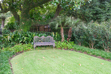 Landscaped Yard with Shades of Green and Ornamental Metal Bench