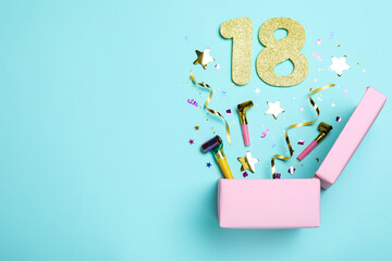 Flat lay composition with decor and numbers on light blue background, space for text. 18th birthday party