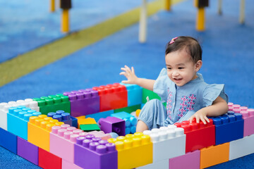 Fototapeta na wymiar Asian cute baby girl enjoying with the building blocks in the playground
