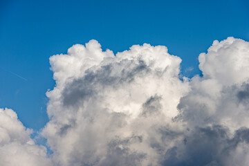 Naklejka na ściany i meble Beautiful storm clouds, cumulus clouds or cumulonimbus against a clear blue sky. Photography, Full frame.