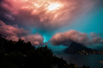 Stormy clouds over the city of Lugano during summer time.  Lightning above the lake