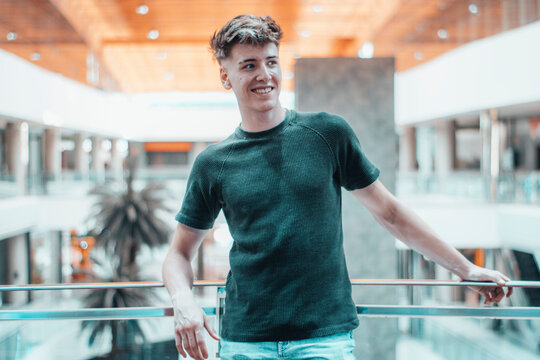 Hombre joven mirando en el centro comercial con una sonrisa y felicidad