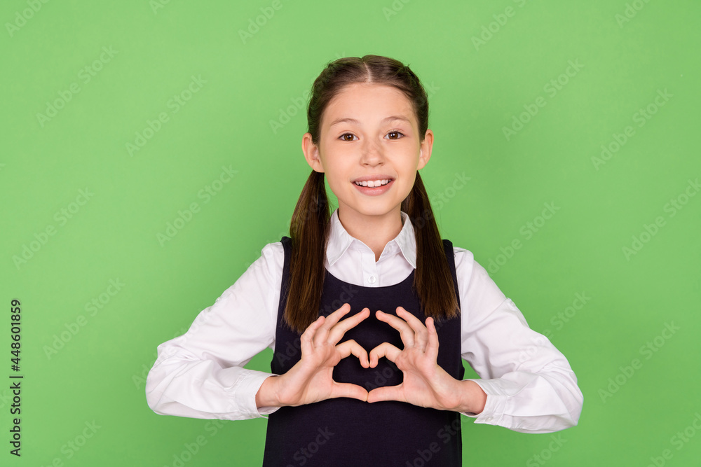 Sticker Photo portrait little girl smiling happy showing heart sign with fingers isolated pastel green color background