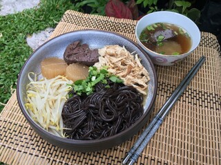 Black noodles and boiled chicken with chicken soup