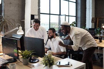 Young successful businessmen looking at computer screen with smiles