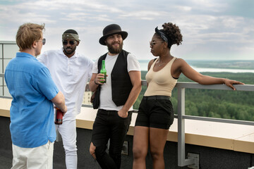 Group of intercultural young people having party in outdoor cafe